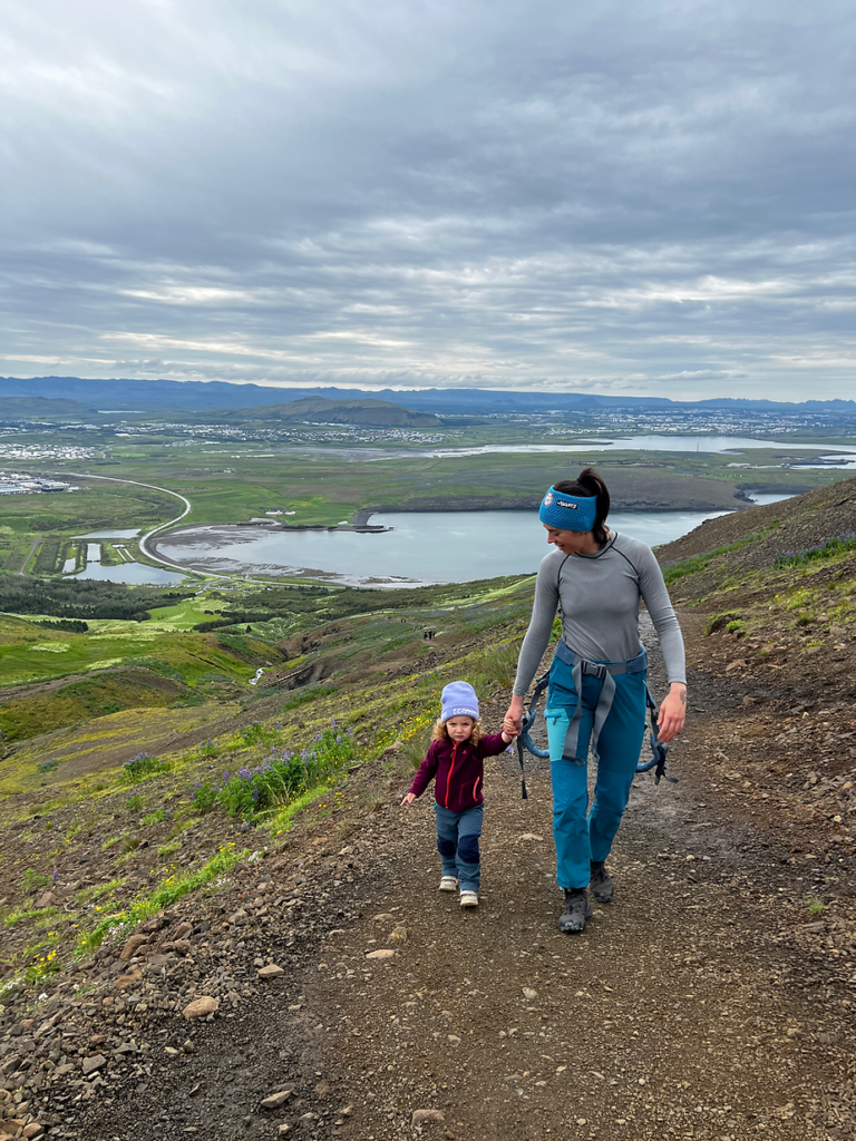 mom holds the hand of her child while hiking in iceland