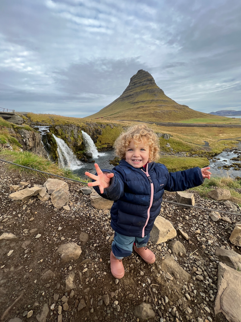 younge child stands with her hands out to the side while hiking in iceland.