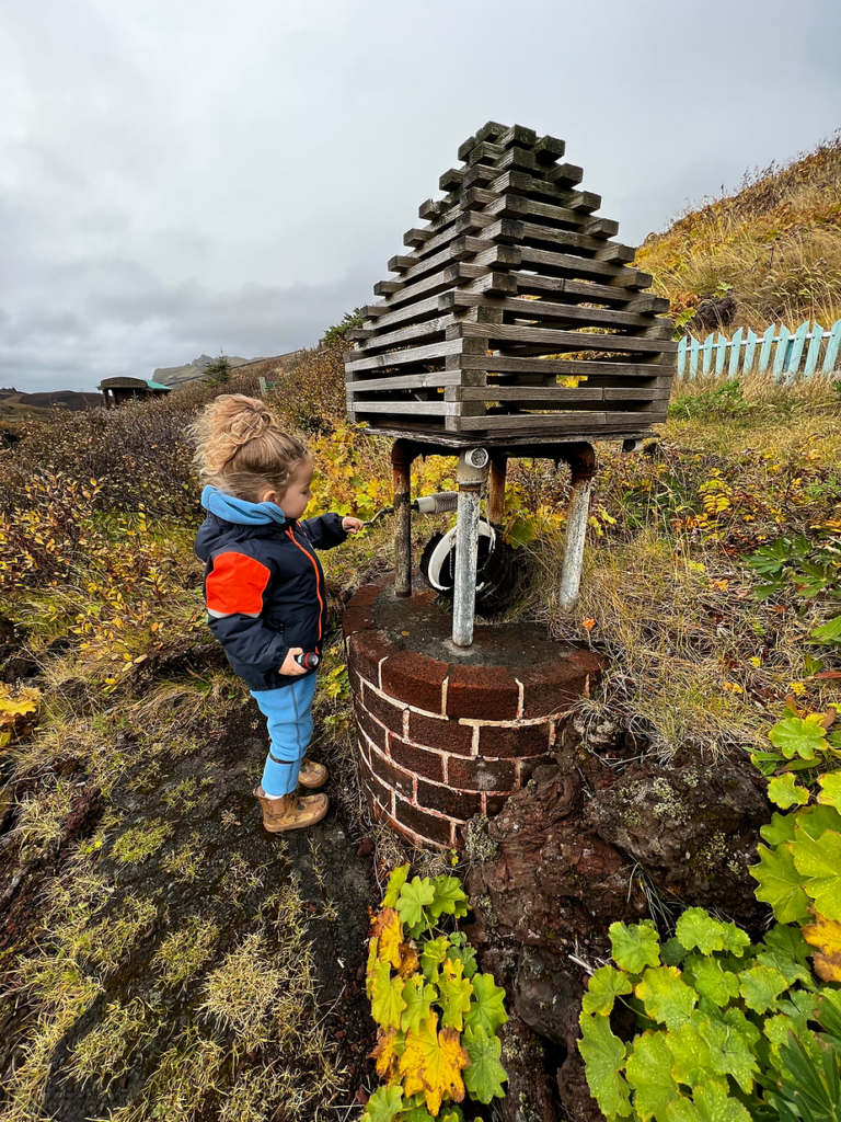 child plays with water well in iceland