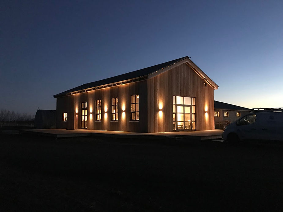 A lit wedding venue at dusk with warm glowing lights. during iceland reception