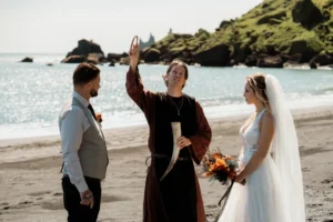bride and groom say wedding vows on beach during Ásatrú Ceremony in iceland