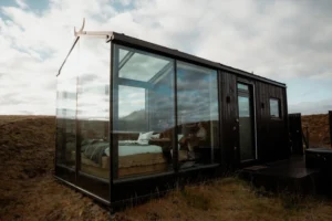 glass cabin stands in iceland for an elopement