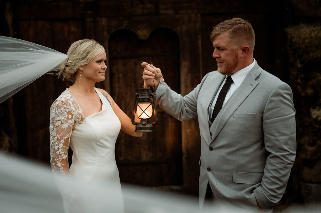 Bride and groom stand together, holding a lantern during Ásatrú elopement ceremony in iceland
