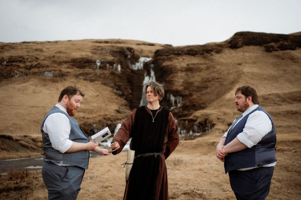 two grooms read wedding vows during Ásatrú elopement ceremony in iceland
