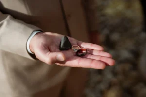 groom holds ring and rocks in hand during iceland wedding