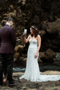 bride and groom hold horns filled with a drink during Ásatrú Ceremony in iceland