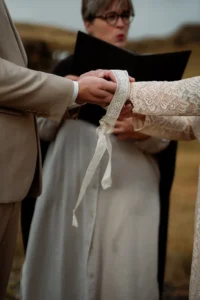 bride and groom do handfasting during Ásatrú Ceremony in iceland