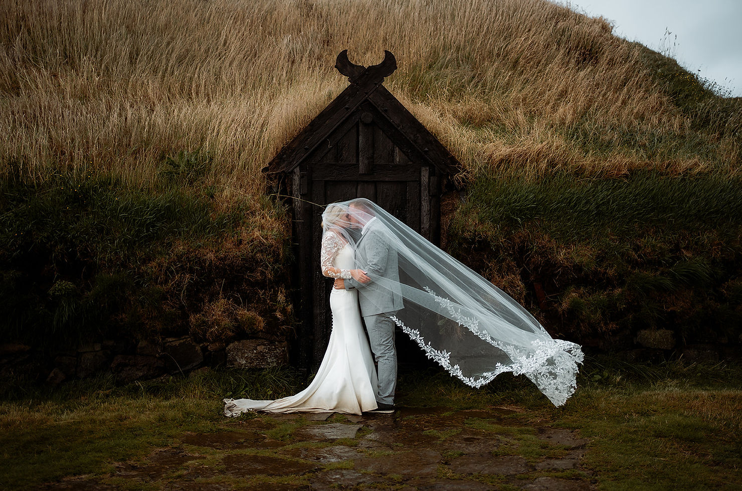 Couple sharing vows during an Ásatrú ceremony in Iceland turf house