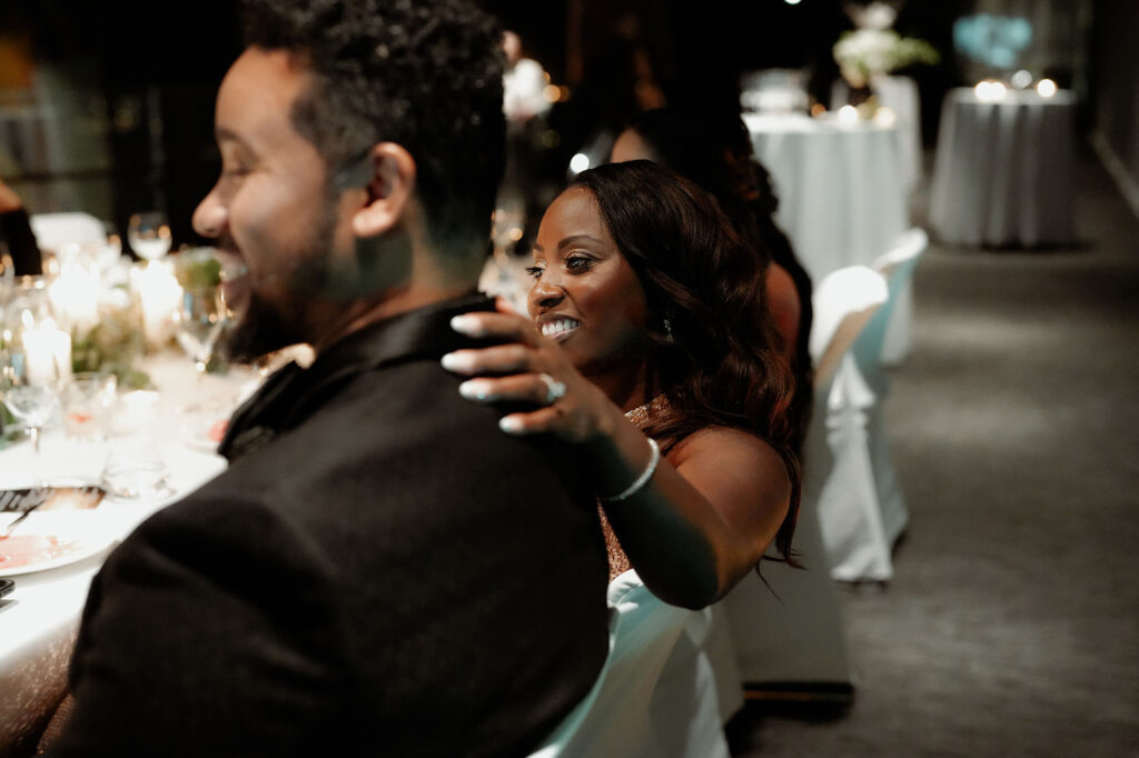 How to Include Your Family When You Elope: married couple sits at wedding table during wedding reception