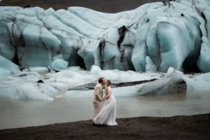 at Solheimajokull Glacier, bride and groom kiss in front of a big glacier while eloping in iceland