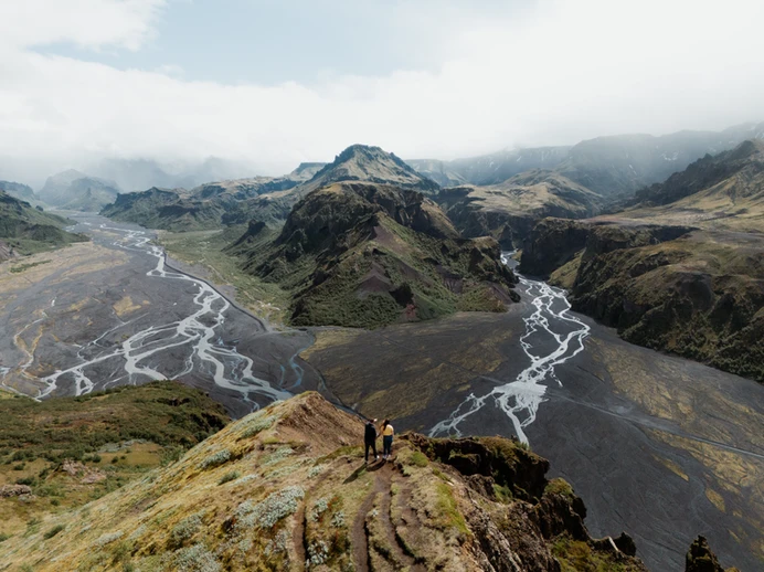 a couples is standing on an overlook at Þórsmörk, one of the best places to elope in iceland