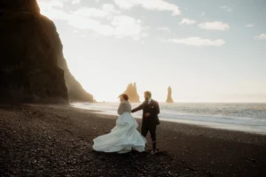 groom twirls bride during elopement photos on icelands black sand beach