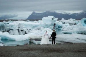 bride and groom hold hands and look out at Jökulsárlón, one of the best places to elope in iceland