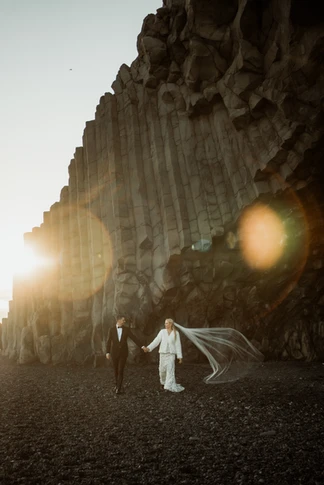 bride and groom hold hands and walk during iceland elopement