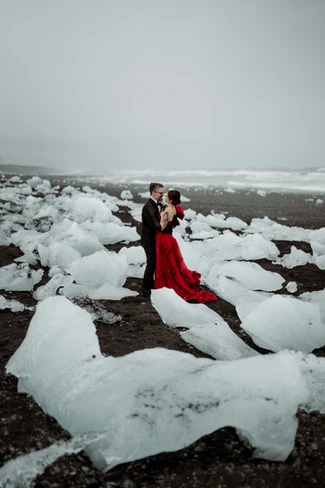 after looking at the cost to elope in iceland, bride and groom stand on diamond beach and say wedding vows
