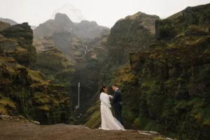 bride and groom say wedding vows in front of gorge and waterfall in iceland during wedding