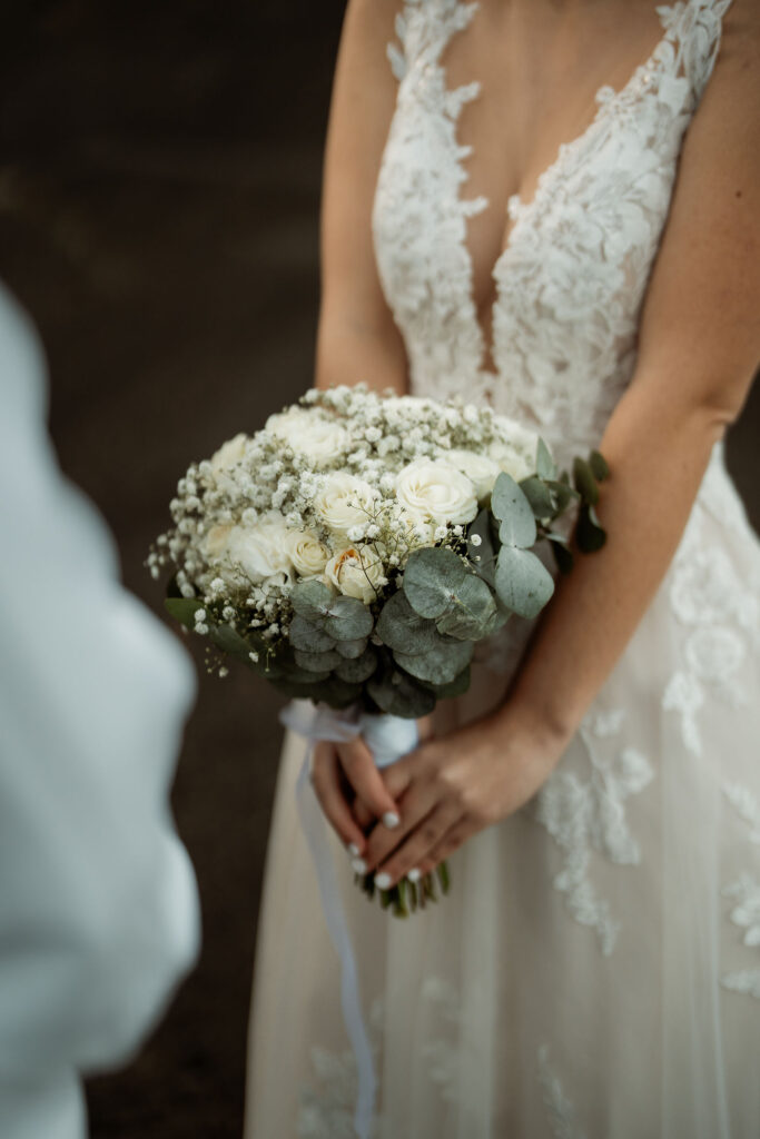 bride holds on to white and green simple elopement bouquet for iceland wedding