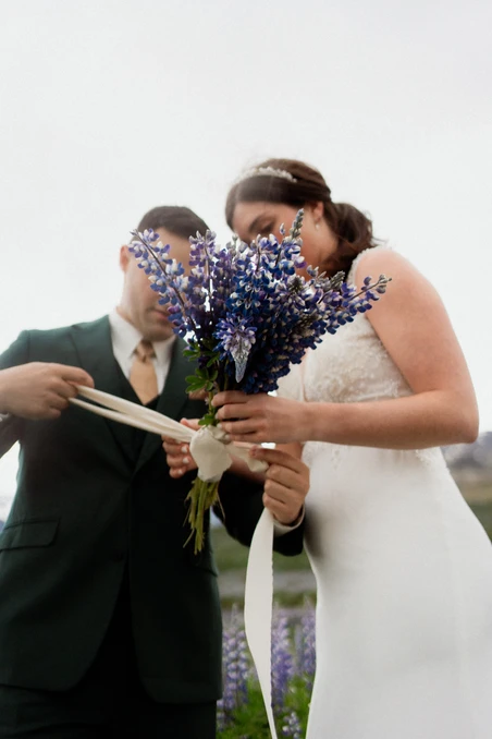 bride and groom tie togehter their own DIY elopement bouquet