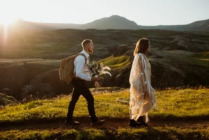 bride and groom walk on trail in iceland during elopement while groom holds bouquet