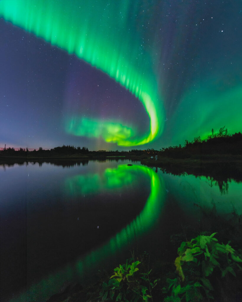 northern lights reflects off water during iceland elopement