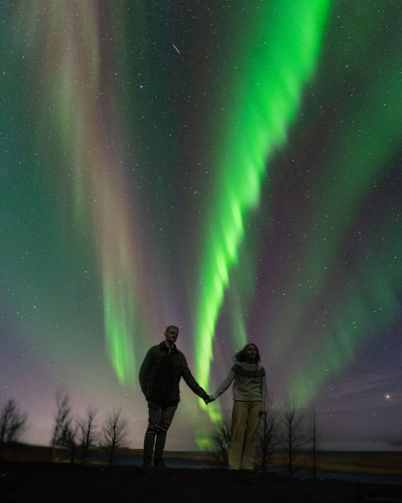 couple holds hands during northern lights wedding in iceland