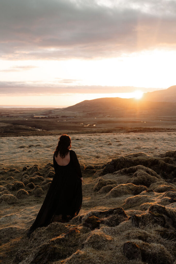 Beautiful bride in black wedding dress, overlooks the valley during Intimate Elopement Photos with Iceland Wedding Photographer.