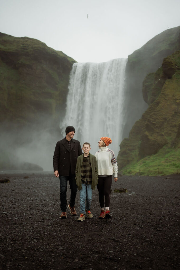 Family in front of waterfall during photos by iceland wedding photographer.