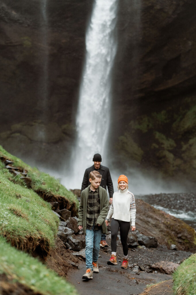 Family hikes near waterfall during Iceland Family Photo Session.