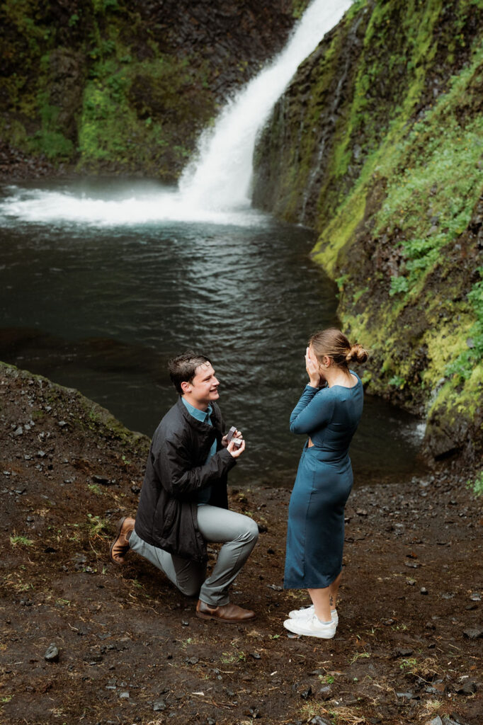 man gets down on one knee and proposes to woman during iceland proposal photo shoot.