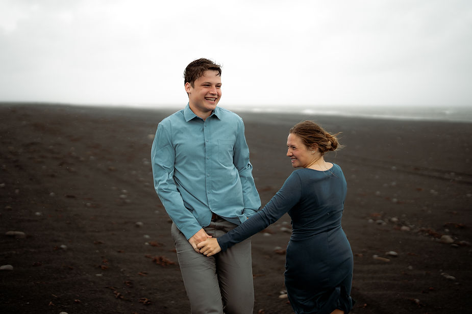 engaged couple holds hands and smiles during engagement pictures with iceland elopement photographer
