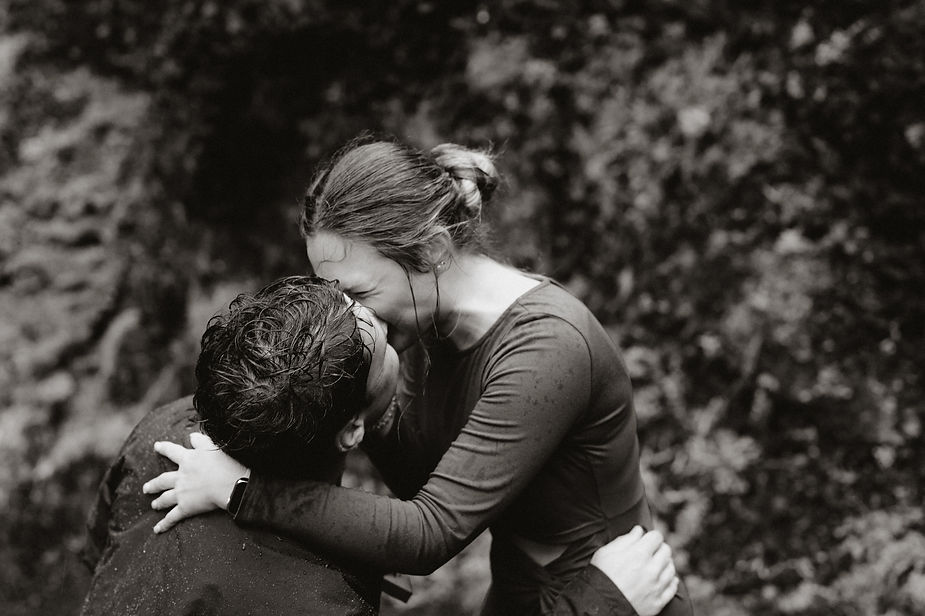 man and woman kiss during iceland surprise proposal.