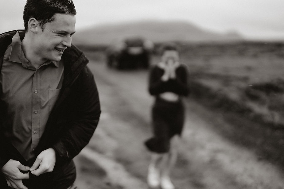close up of man, with woman in the background out of focus, during iceland proposal.