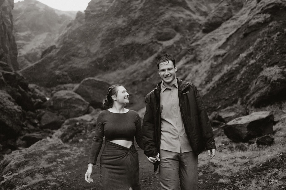 engaged couple holds hands and walks down trail during iceland engagement pictures with elopement photographer.