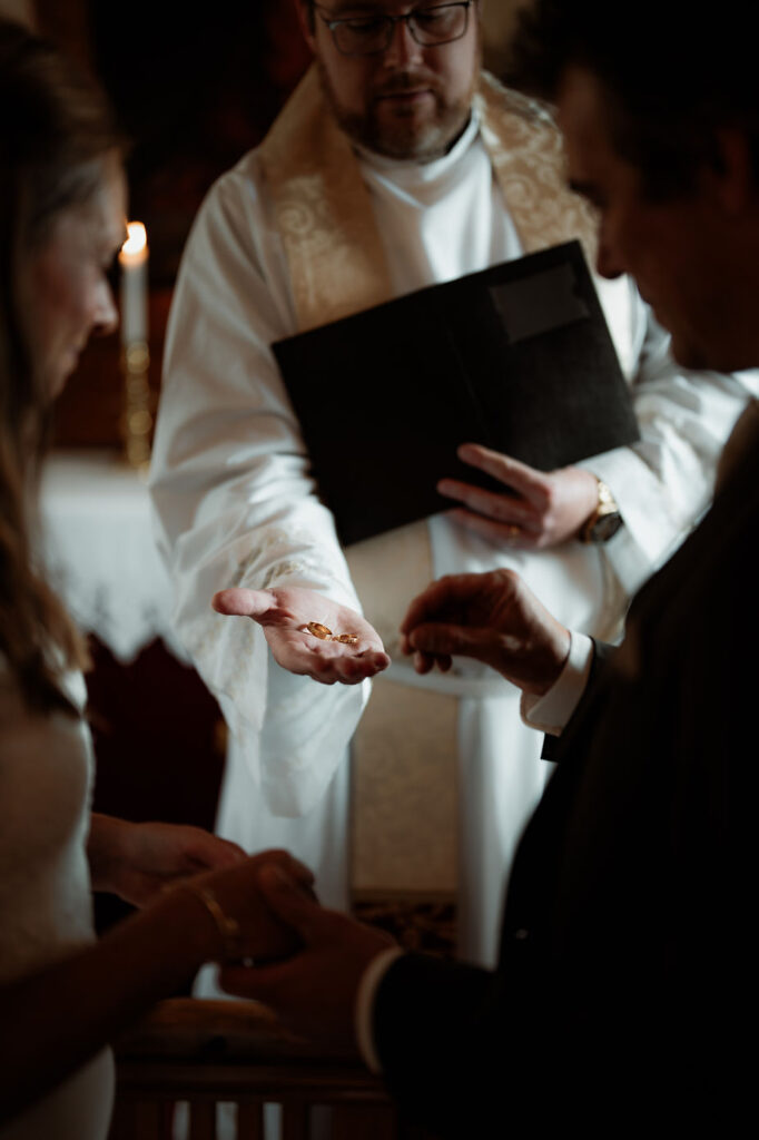 bride and groom exchange rings during iceland wedding ceremony.