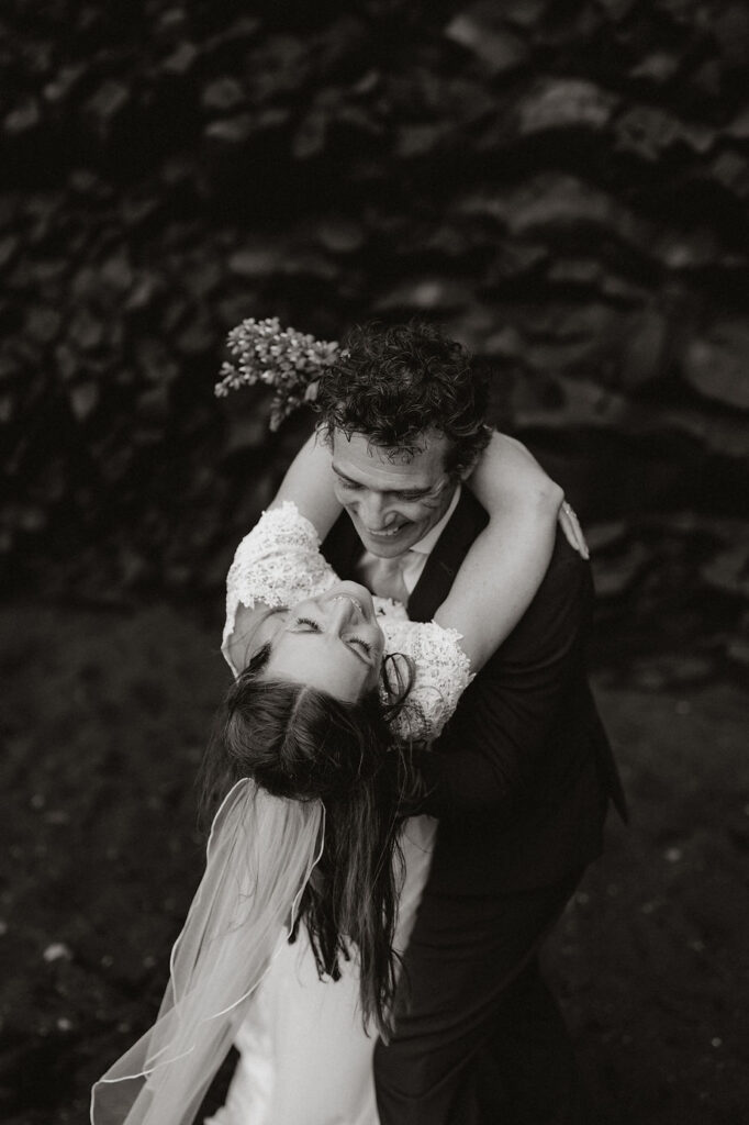 bride and groom embrace each other and laugh during iceland wedding photo shoot.