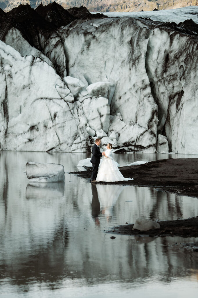 Iceland elopement photographer captures a newlywed couple beside a glacier.