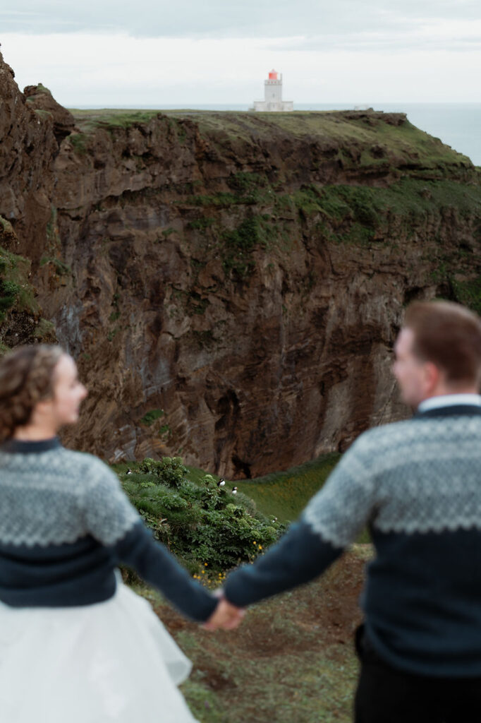 newlywed couple stands overlooking cliff edge in iceland during adventure elopement.