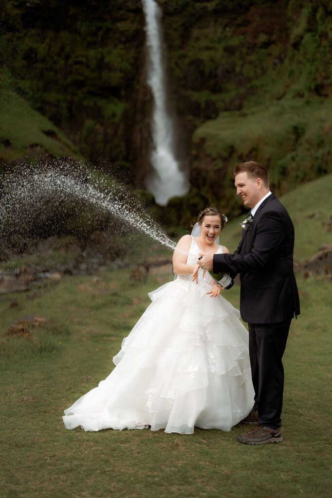 bride and groom pop a bottle of champagne during dreamy iceland wedding.