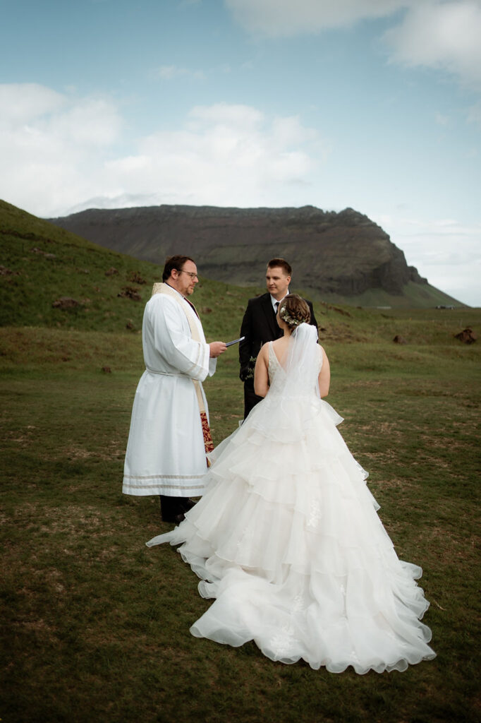 priest marries bride and groom during iceland adventure wedding.