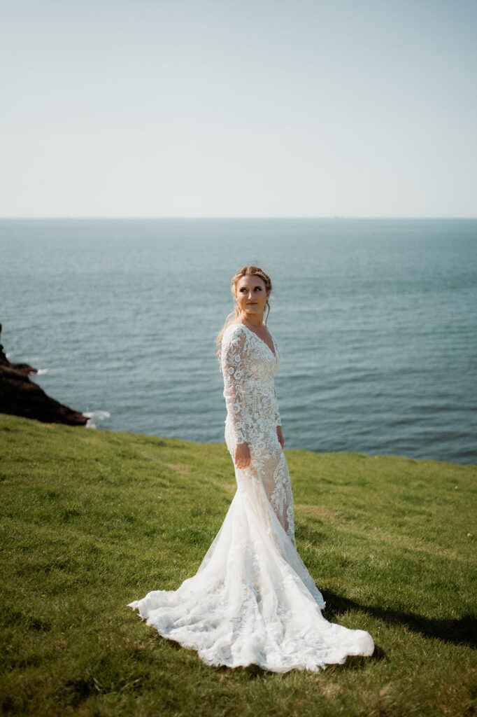 bride stands on coast during iceland wedding portraits with iceland elopement photographer.
