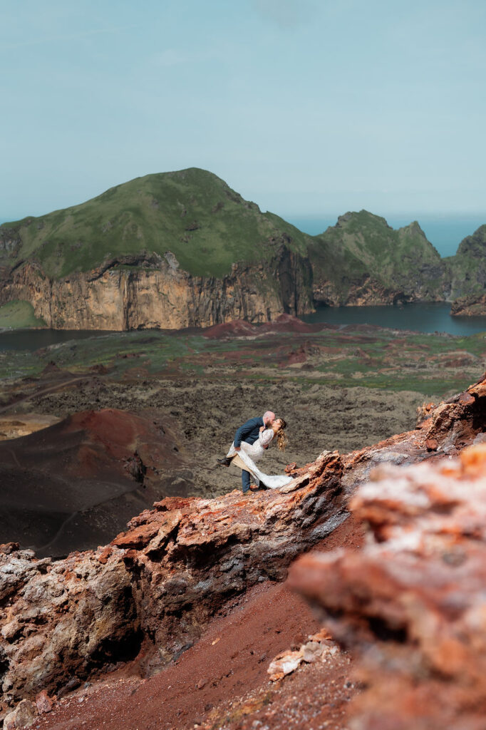 bride and groom kiss overlooking the westman islands during iceland wedding photo shoot.
