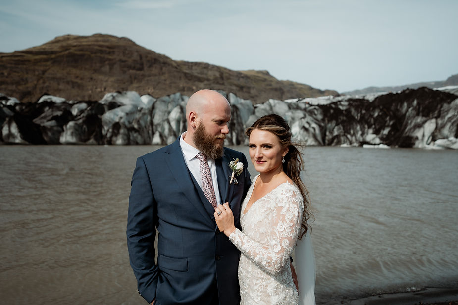 bride and groom stand in front of glaicer during iceland elopement photo session.