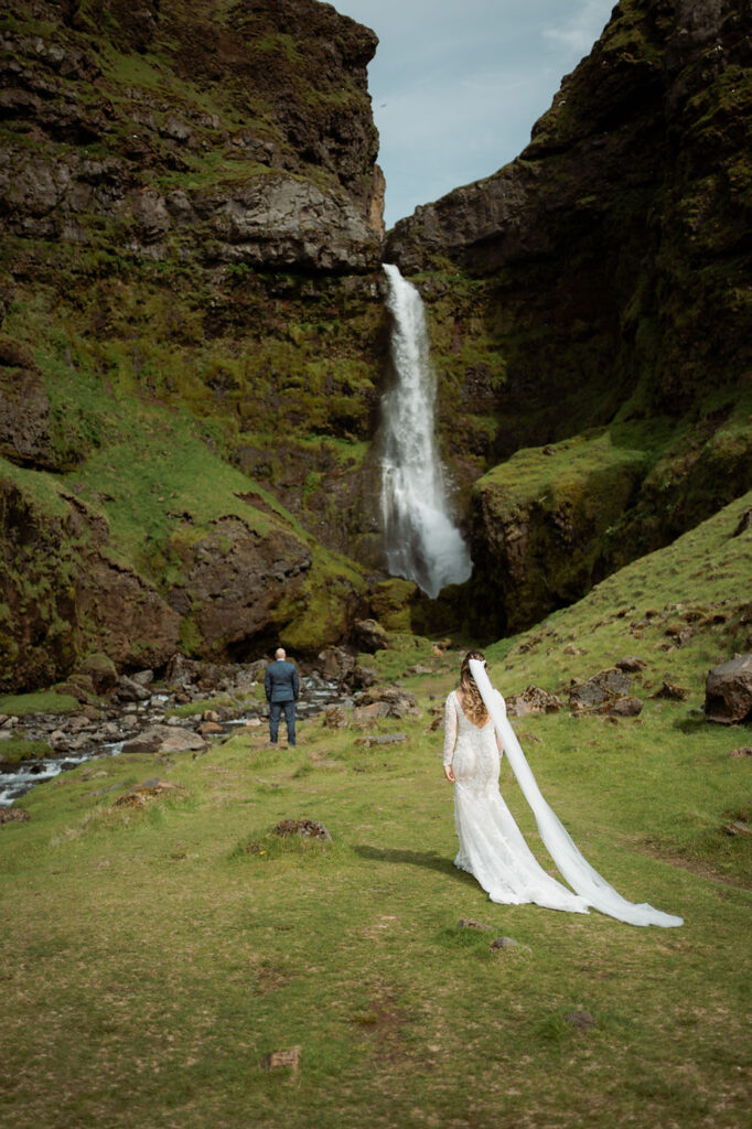 bride stands behind groom for first look during iceland adventure elopement photos.