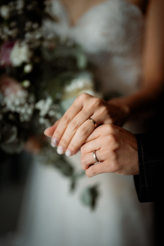 close up image of a couples hands and wedding rings during their iceland wedding photos.