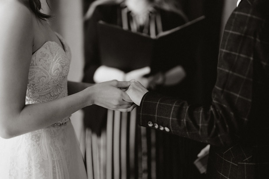 partners hold hands during iceland wedding ceremony.