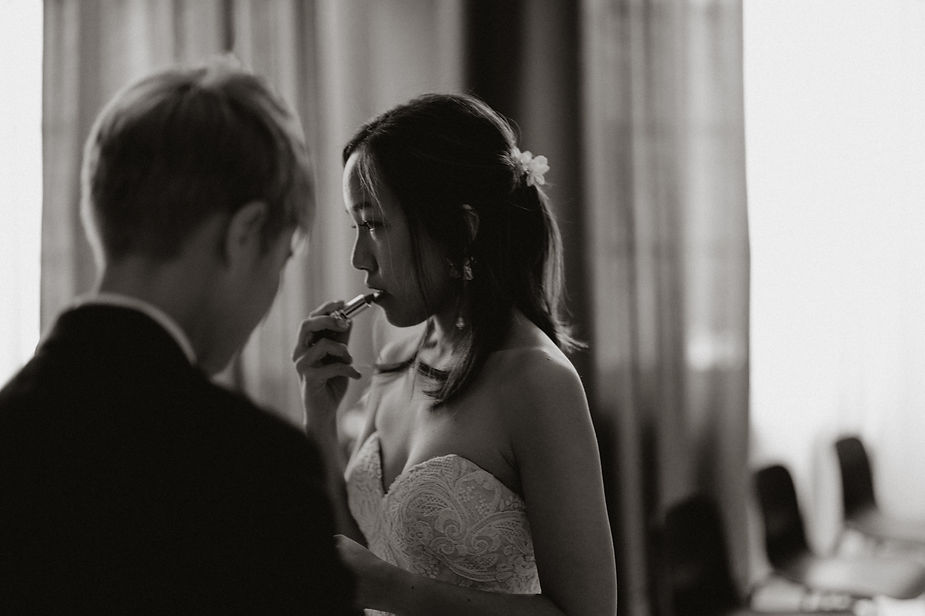 bride puts lipstick on herself before destination wedding in iceland.