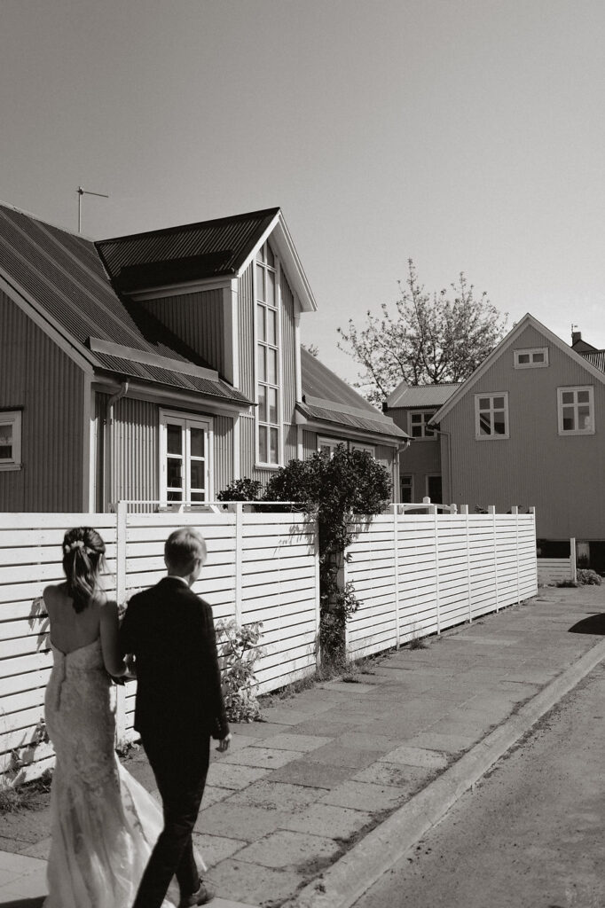 married couple walk hand in hand down the streets of reykjavik during destination wedding in iceland.