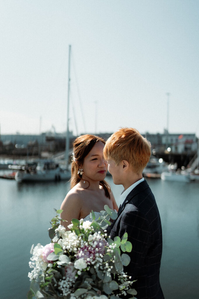 newly married couple embraces each other on reykjavik harbour during their iceland elopement photos.