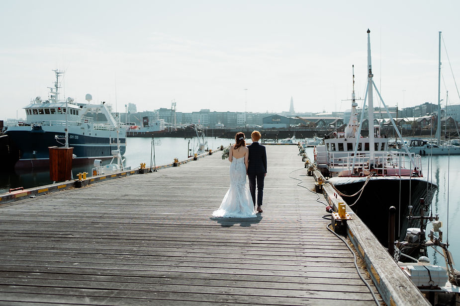 lgbtqi+ couple walk down reykjavik harbour during iceland wedding photos.