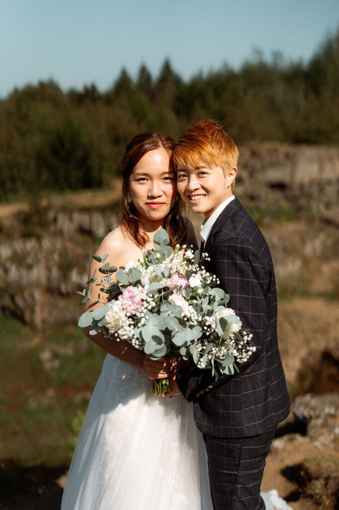 lgbtqi+ couple embraces each other and smile during their wedding photos in reykjavik iceland.